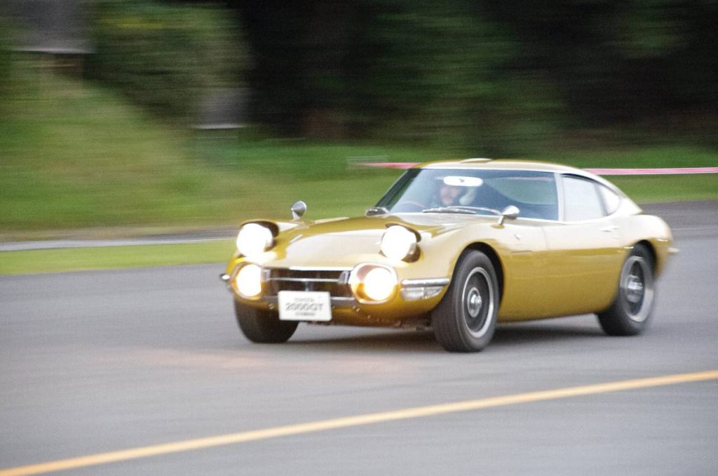 リトラクタブルヘッドライトを上げて走行するトヨタ 2000GT